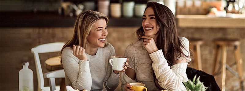 Mujeres sonrientes tomando café