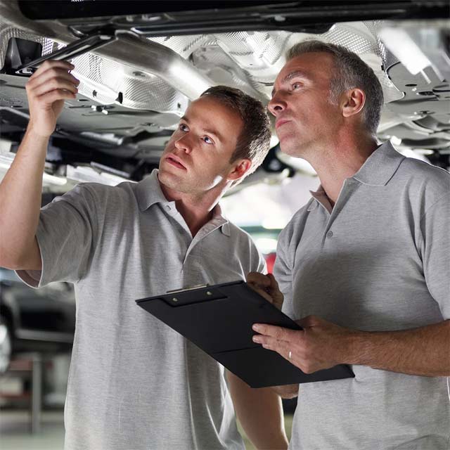Hombres mecánicos revisando un auto
