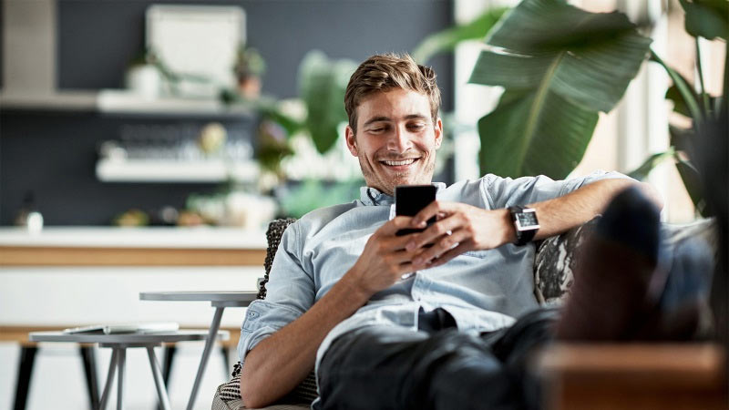 Hombre sonriente mirando su celular