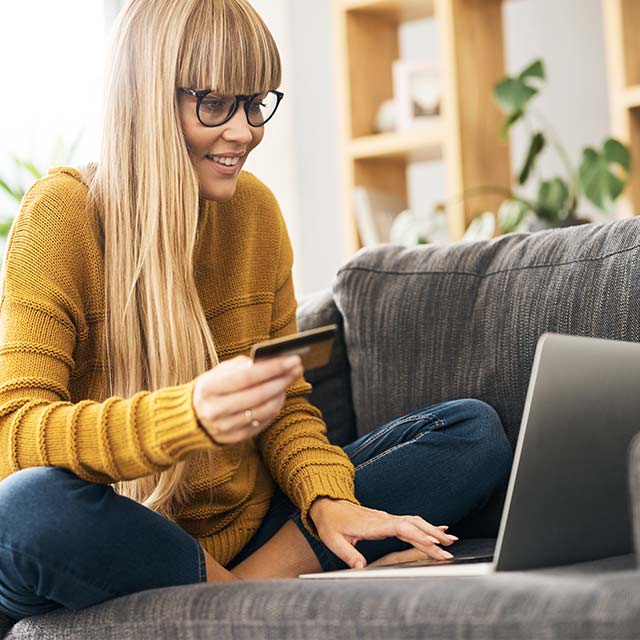 Mujer comprando online sentada en un sillon