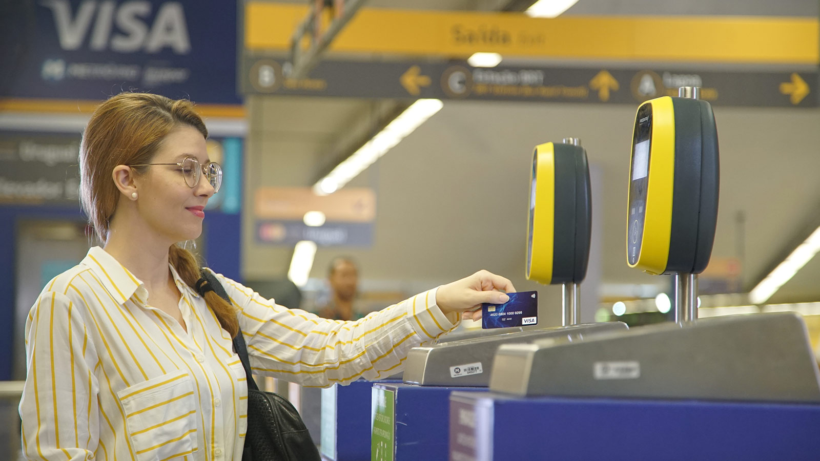 Mujer pagando con tarjeta Visa