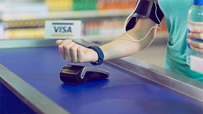 Mujer pagando con dispositivo wearable