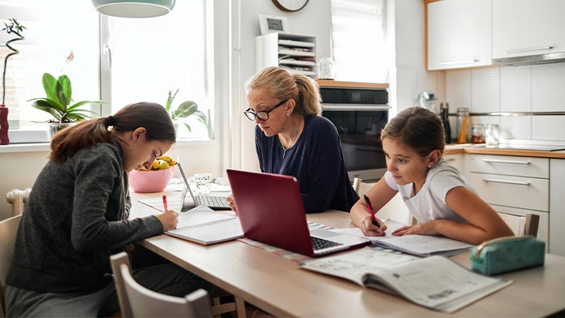 Madre e hijas haciendo deberes escolares