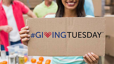 Mujer sonriente sosteniendo un carte de Giving Tuesday