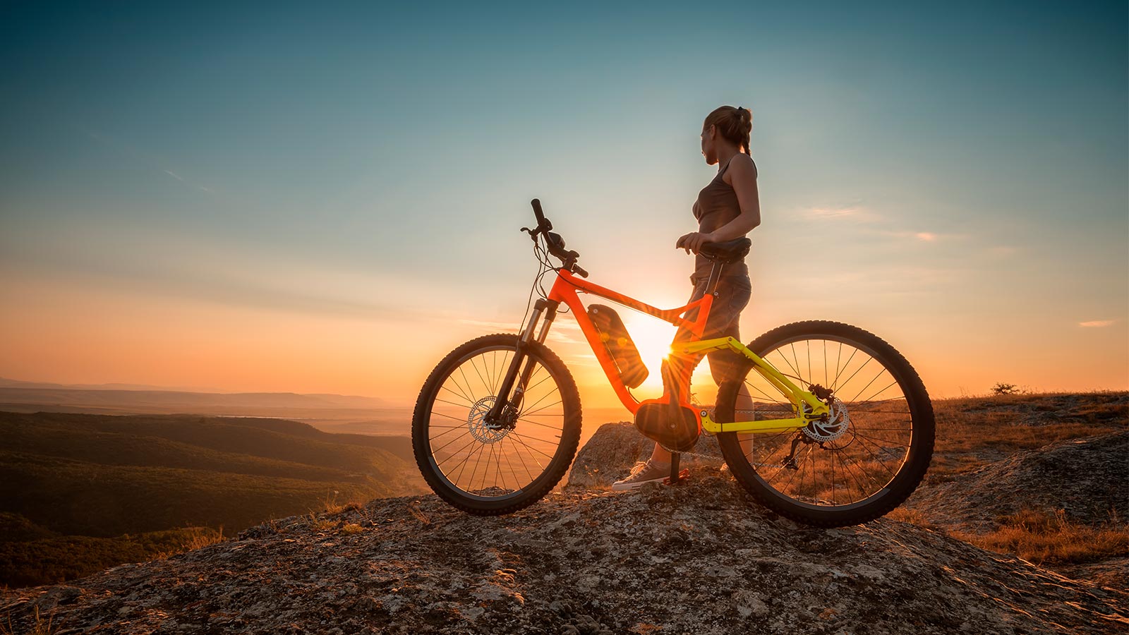 Mujer con bicicleta en una montaña